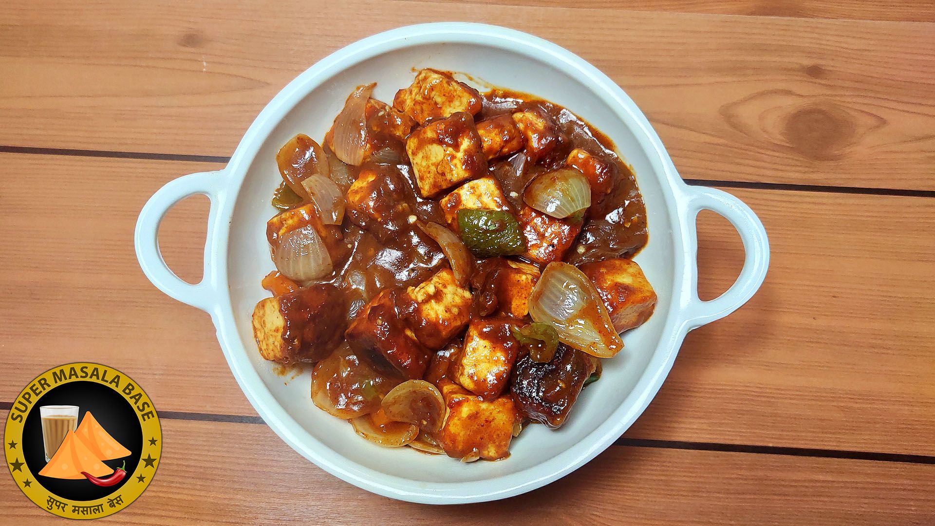 chilli paneer cottage cheese in hot sauce mixed with onions capsicum pieces