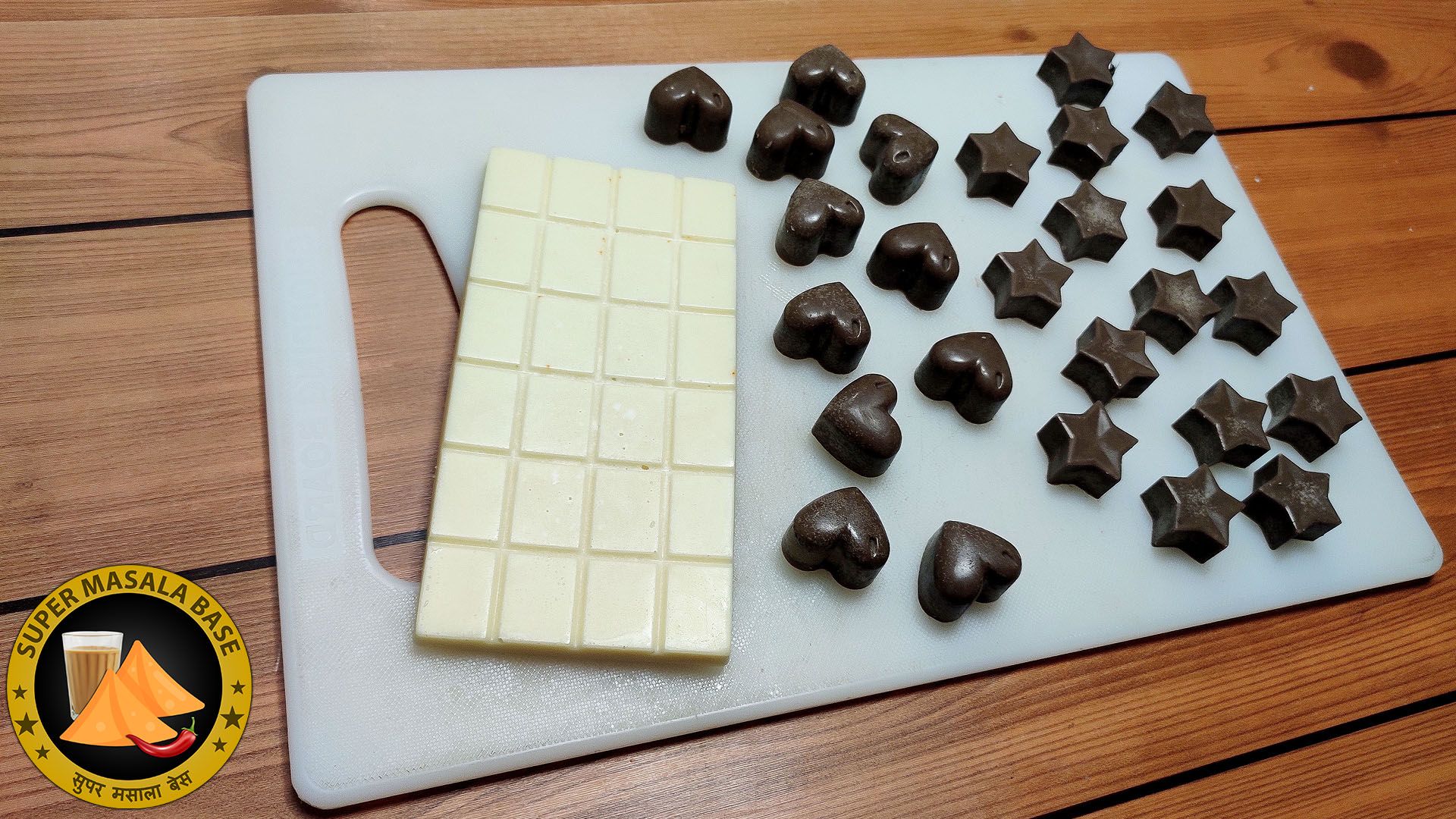white milk chocolate bar with star heart shaped brown pieces using cocoa powder on shown cutting board